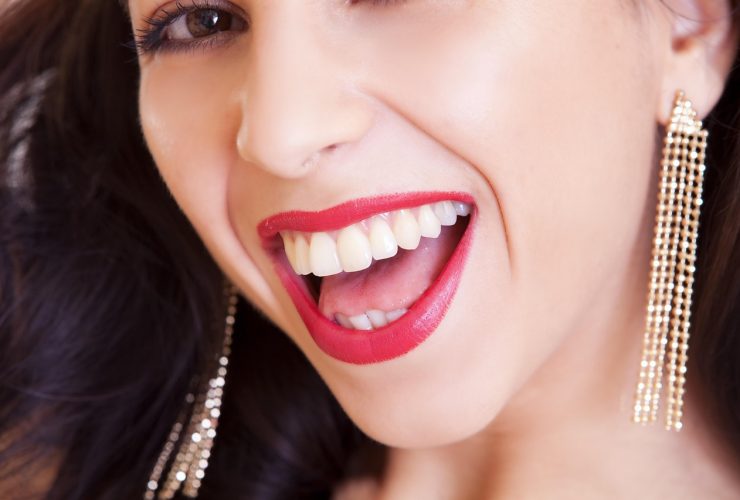 Vrouw met meerdere gouden en zilveren oorknoppen in verschillende formaten in een ear party opstelling