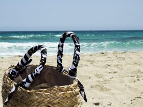 Geweven strandtas liggend op zand bij de zee