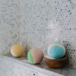 Rijen beautyproducten op een badkamerplank, waaronder lotions en gezichtsverzorging in meerdere flacons