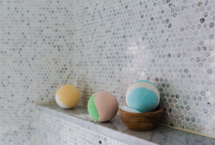 Rijen beautyproducten op een badkamerplank, waaronder lotions en gezichtsverzorging in meerdere flacons
