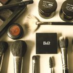 Diverse make-upproducten zoals foundation, concealer en highlighter uitgestald op een witte ondergrond