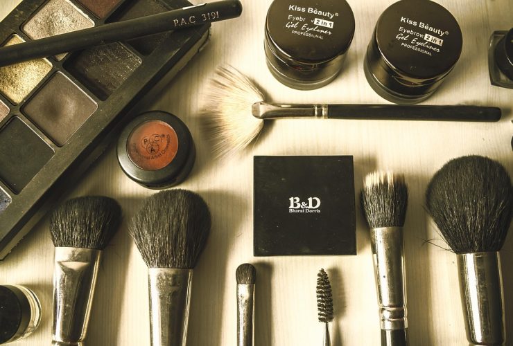 Diverse make-upproducten zoals foundation, concealer en highlighter uitgestald op een witte ondergrond