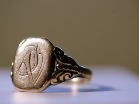 Juwelier die een gouden ring nauwkeurig inspecteert met een loep in een werkplaats
