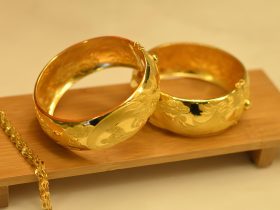 Een gouden erfstuk ring naast een modern sieradeontwerp op een witte achtergrond