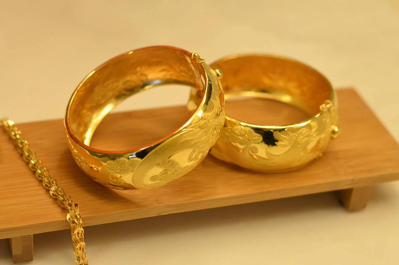 Een gouden erfstuk ring naast een modern sieradeontwerp op een witte achtergrond