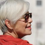 Vrouw bekijkt haar nieuwe herfstkapsel in de spiegel bij de kapper