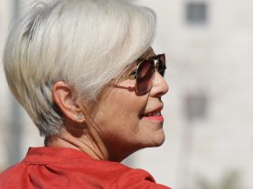 Vrouw bekijkt haar nieuwe herfstkapsel in de spiegel bij de kapper