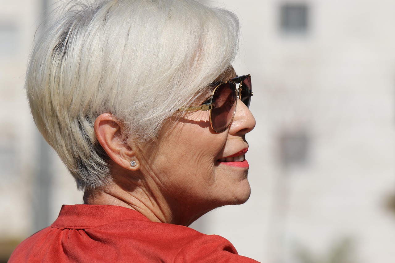 Vrouw bekijkt haar nieuwe herfstkapsel in de spiegel bij de kapper