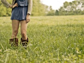 Vrouw in kniehoge laarzen en midi-rok in herfststijl