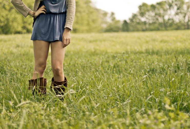 Vrouw in kniehoge laarzen en midi-rok in herfststijl
