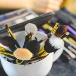 Verschillende make-upproducten uitgestald op een witte ondergrond, waaronder mascara, foundation en lippenstift