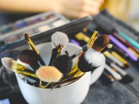 Verschillende make-upproducten uitgestald op een witte ondergrond, waaronder mascara, foundation en lippenstift