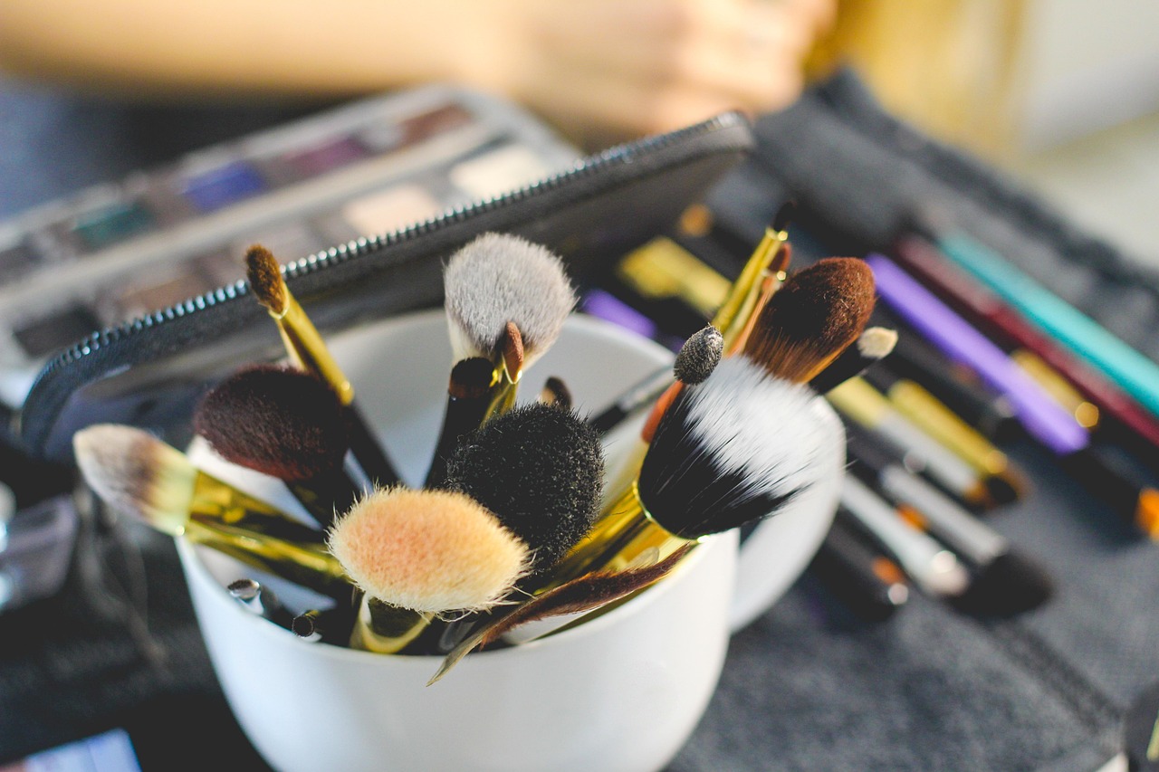 Verschillende make-upproducten uitgestald op een witte ondergrond, waaronder mascara, foundation en lippenstift