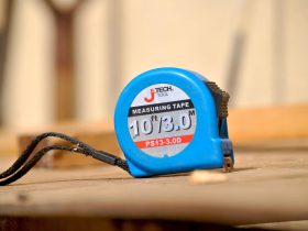 Centimeterband, papierstrookje en sieraden op een witte ondergrond voor het opmeten van ringmaat en polsomtrek